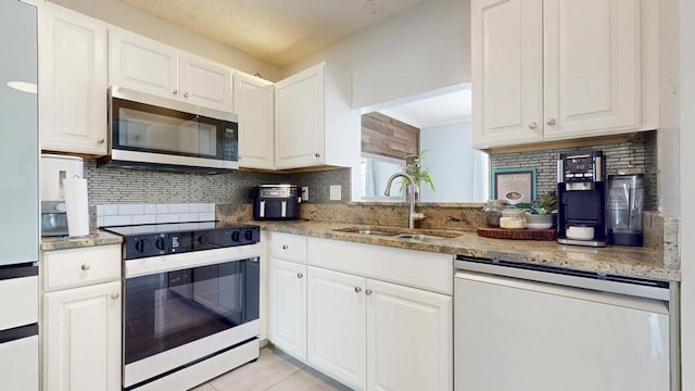 kitchen featuring white cabinets, electric range oven, dishwasher, stainless steel microwave, and a sink