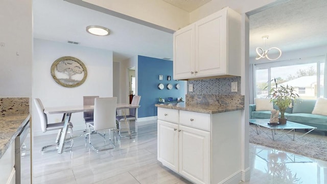 kitchen with a chandelier, backsplash, visible vents, and white cabinets