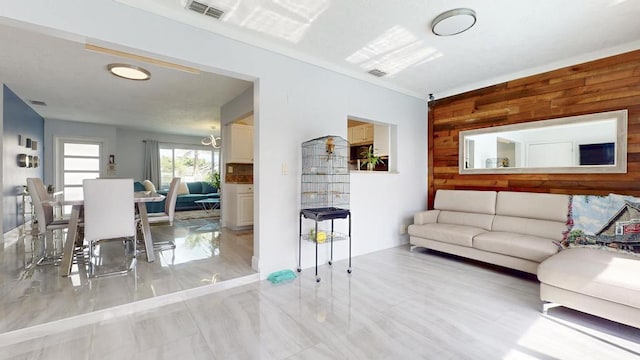 living area with wood walls and visible vents