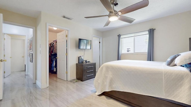 bedroom featuring ceiling fan, visible vents, baseboards, a spacious closet, and a closet