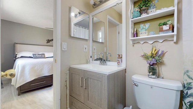 ensuite bathroom with vanity, ensuite bath, and toilet