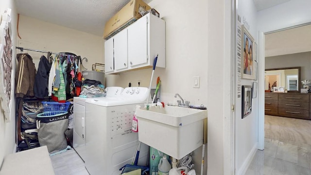 laundry area featuring cabinet space, water heater, washer and clothes dryer, and a sink