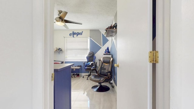 interior space featuring light wood-style floors, ceiling fan, and a textured ceiling