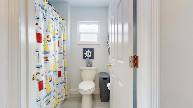 full bathroom featuring a shower with curtain, baseboards, and toilet