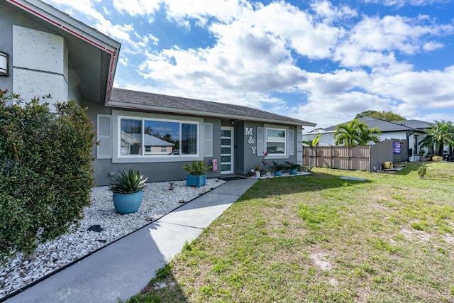 single story home featuring a front yard, fence, and stucco siding