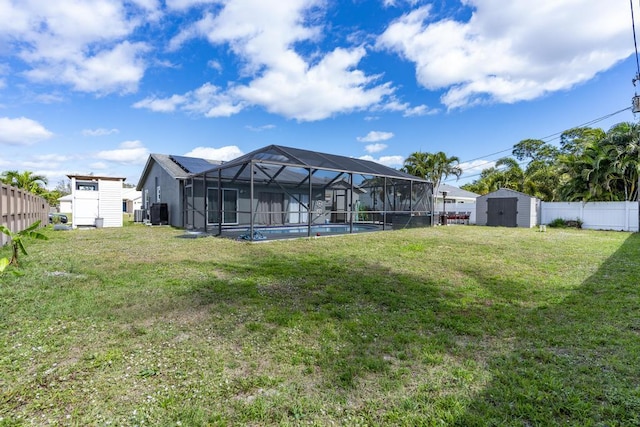 view of yard with a fenced in pool, a fenced backyard, an outbuilding, a lanai, and a shed