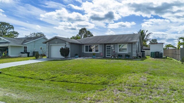 ranch-style house featuring a front yard, concrete driveway, fence, and an attached garage