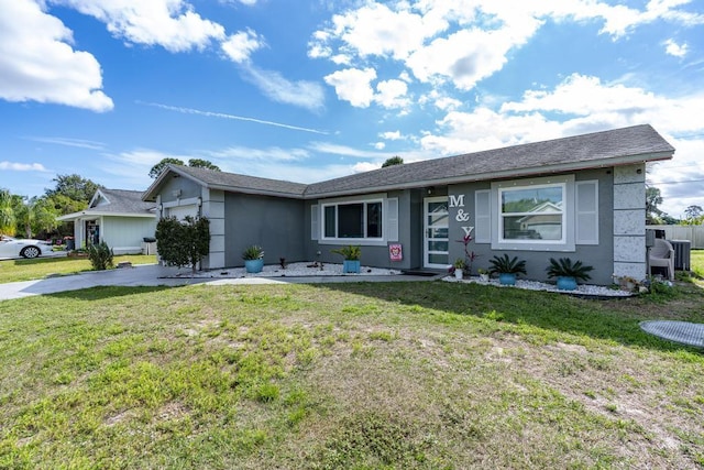 ranch-style house featuring an attached garage, stucco siding, driveway, and a front yard