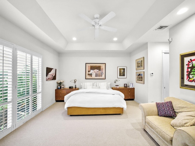 bedroom featuring baseboards, visible vents, light colored carpet, a tray ceiling, and recessed lighting