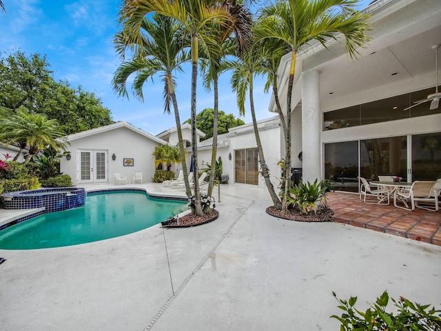 view of pool featuring french doors, a patio area, and a pool with connected hot tub