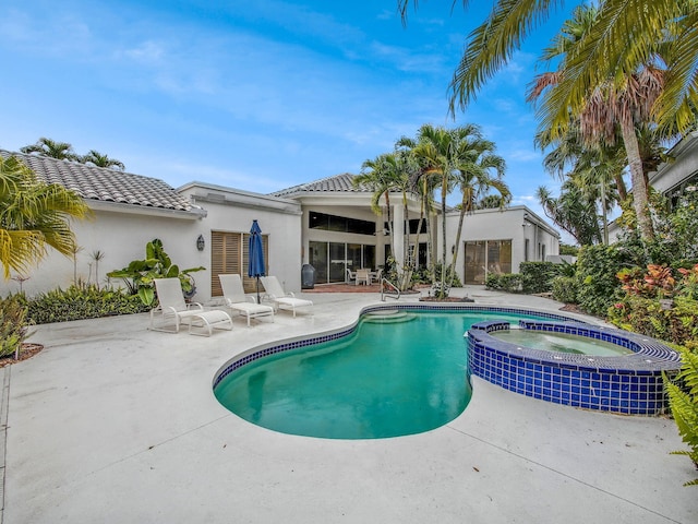 view of pool featuring a patio area and a pool with connected hot tub