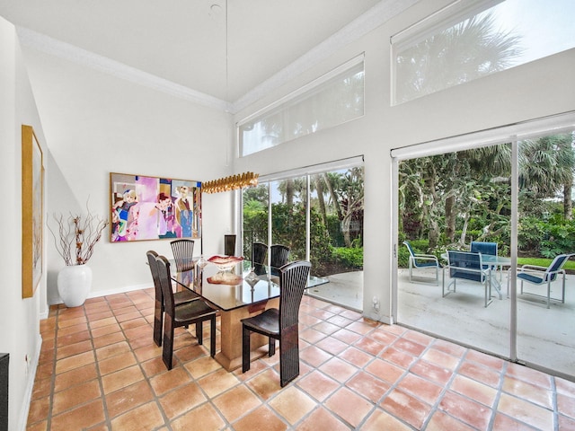 dining space with light tile patterned floors, a high ceiling, and ornamental molding