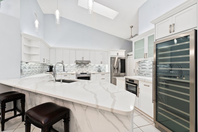 4214 SE Home Way, Port Saint Lucie, FL 34952 - kitchen featuring open shelves, a peninsula, beverage cooler, a sink, and appliances with stainless steel finishes