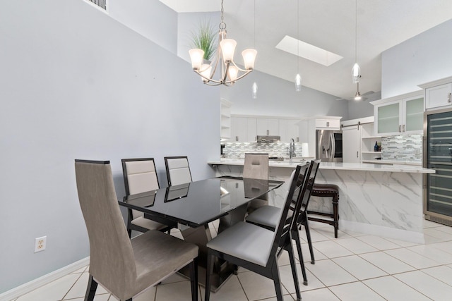 4214 SE Home Way, Port Saint Lucie, FL 34952 - dining space featuring beverage cooler, high vaulted ceiling, a chandelier, light tile patterned floors, and a skylight