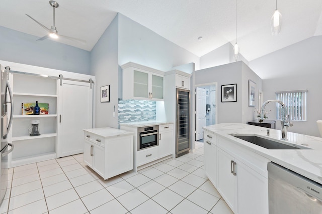 4214 SE Home Way, Port Saint Lucie, FL 34952 - kitchen featuring a barn door, a sink, beverage cooler, stainless steel appliances, and decorative backsplash