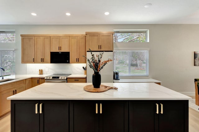 kitchen featuring a kitchen island, black microwave, dark cabinetry, and refrigerator