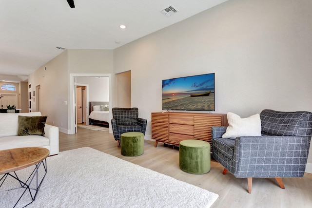 living area with recessed lighting, visible vents, baseboards, and wood finished floors