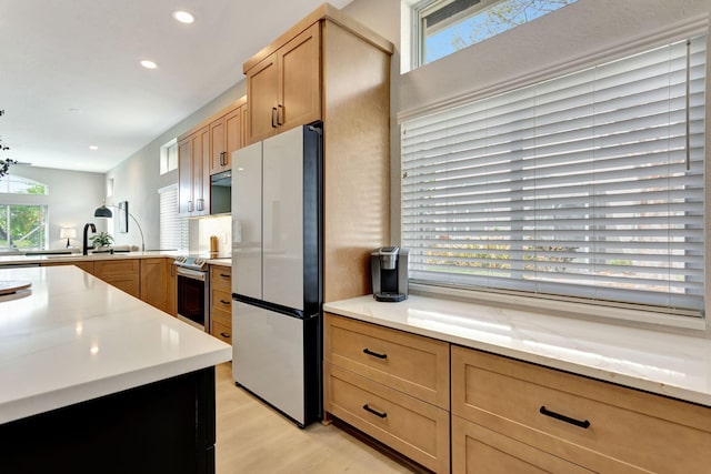 kitchen featuring appliances with stainless steel finishes, recessed lighting, light wood-type flooring, and light countertops