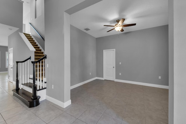 unfurnished room with visible vents, ceiling fan, stairway, and baseboards