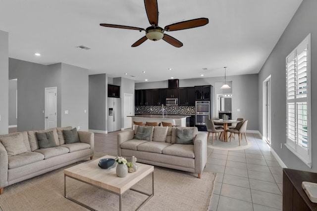 living area with light tile patterned floors, ceiling fan, recessed lighting, visible vents, and baseboards