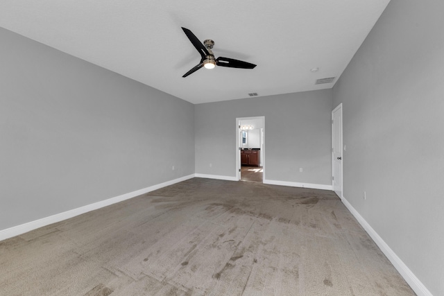 unfurnished bedroom with baseboards, visible vents, connected bathroom, ceiling fan, and carpet