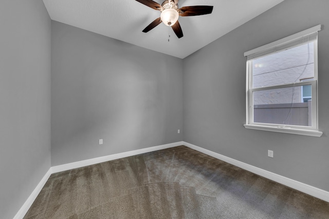 carpeted spare room featuring baseboards and a ceiling fan