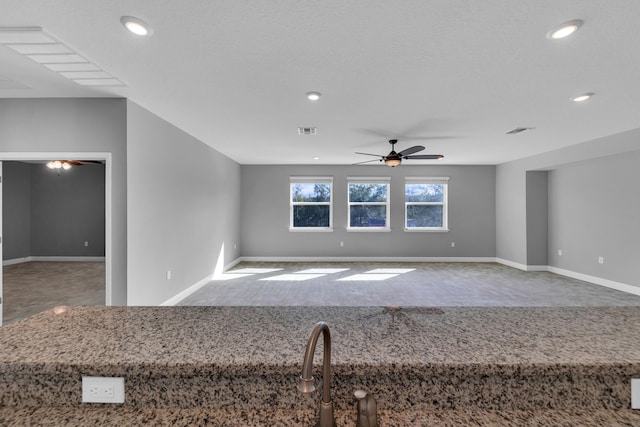 unfurnished room featuring visible vents, ceiling fan, and baseboards