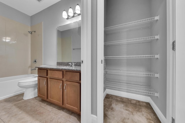 bathroom featuring tile patterned flooring, toilet, vanity, baseboards, and washtub / shower combination