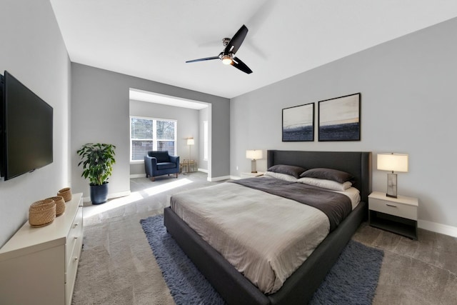 bedroom featuring baseboards, dark carpet, and ceiling fan