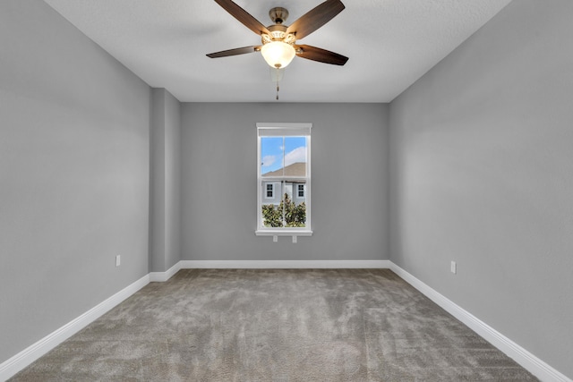 spare room with ceiling fan, baseboards, and carpet flooring