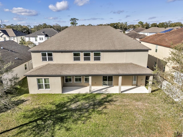 back of house with a shingled roof, a residential view, a patio area, and a yard