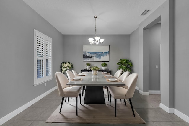 dining room featuring light tile patterned floors, visible vents, baseboards, and an inviting chandelier