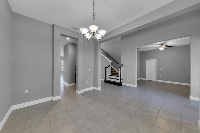 interior space featuring light tile patterned floors, ceiling fan with notable chandelier, visible vents, baseboards, and stairs