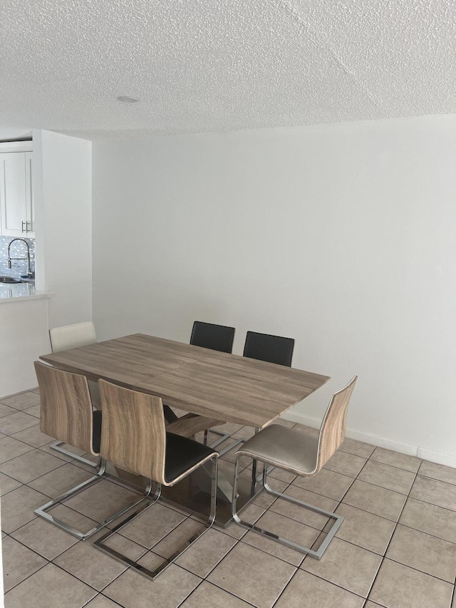 dining space with light tile patterned floors and a textured ceiling