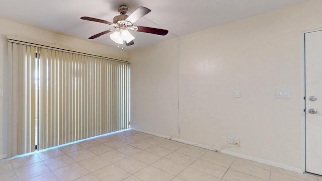 empty room with a ceiling fan, baseboards, and light tile patterned floors