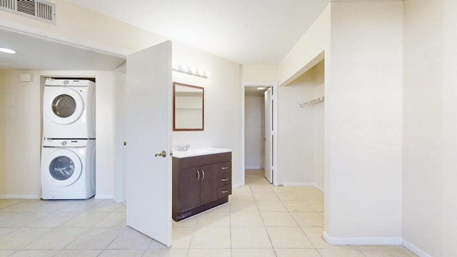 washroom with laundry area, visible vents, stacked washing maching and dryer, and light tile patterned floors