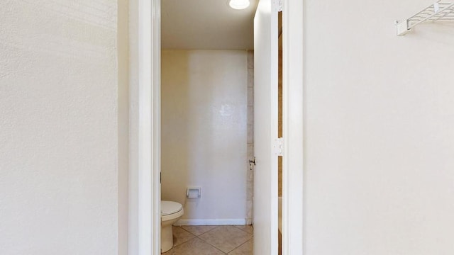 bathroom featuring baseboards, toilet, and tile patterned floors