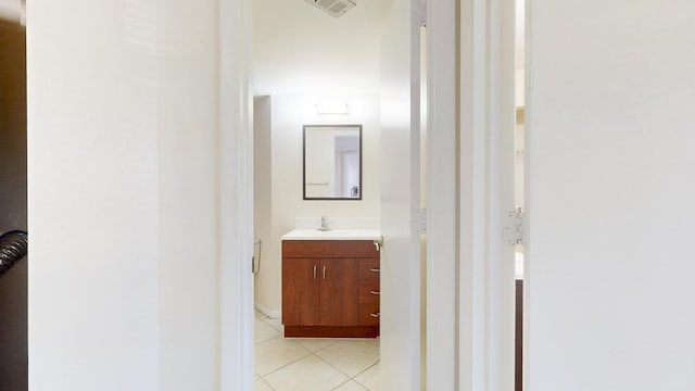 half bath featuring tile patterned flooring, visible vents, and vanity