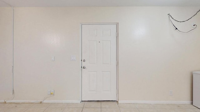 unfurnished room with light tile patterned floors and baseboards