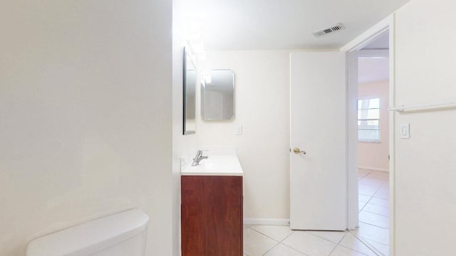 bathroom with visible vents, toilet, vanity, baseboards, and tile patterned floors