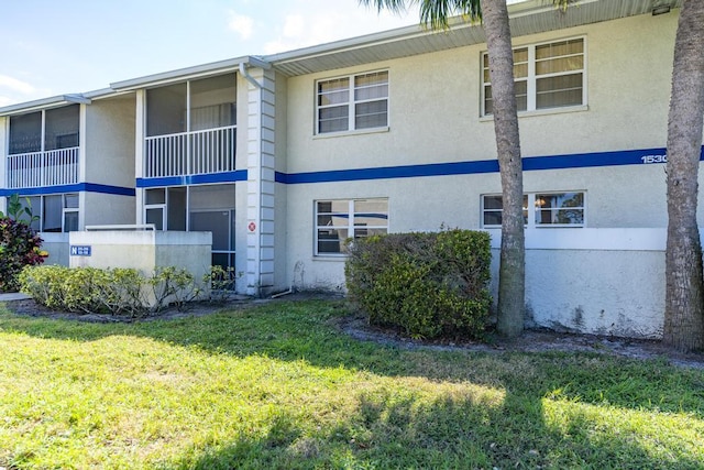 view of property exterior with stucco siding and a yard