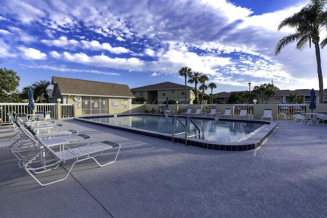 pool featuring a residential view, a patio area, and fence