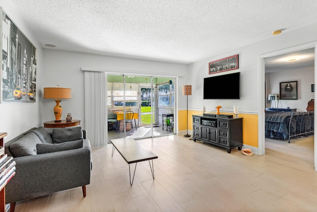 living area with light wood-style floors and a textured ceiling