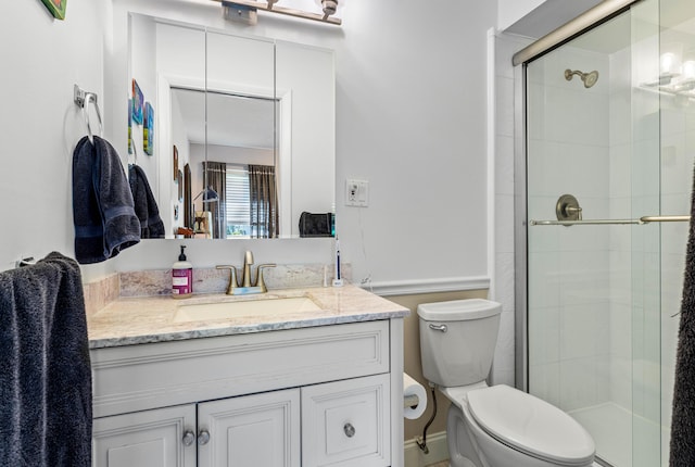 full bathroom featuring vanity, a shower stall, and toilet