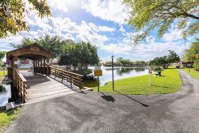 view of community with a water view and a lawn