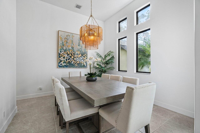 dining space featuring light tile patterned floors, a notable chandelier, visible vents, and baseboards