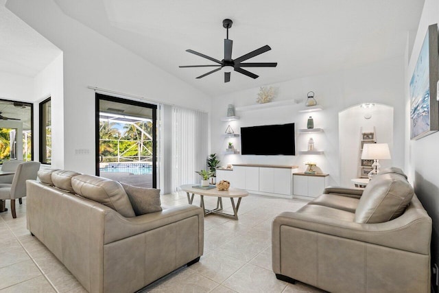 living room featuring lofted ceiling, light tile patterned floors, and ceiling fan