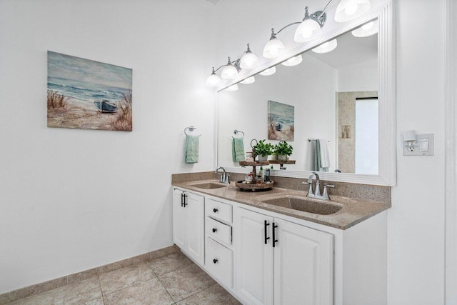 full bathroom featuring tile patterned floors, a sink, baseboards, and double vanity