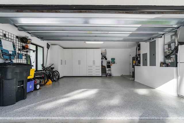 garage featuring electric water heater, freestanding refrigerator, and electric panel