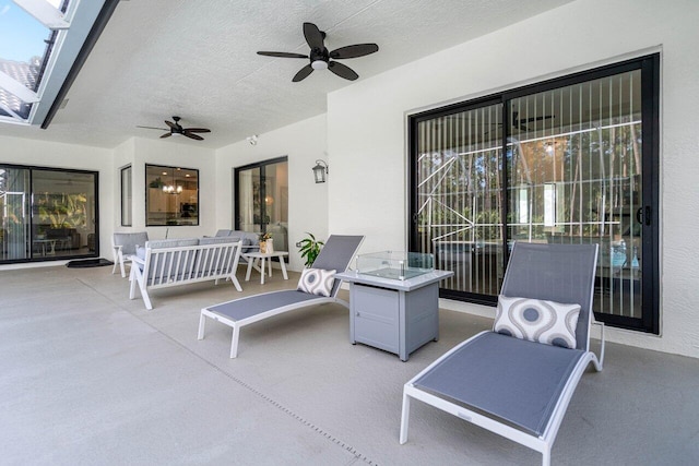 view of patio / terrace with an outdoor living space with a fire pit and ceiling fan